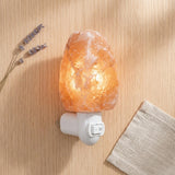 Himalayan salt lamp on a wooden surface with lavender and a blanket.